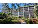 Beautiful condo building with lush landscaping, manicured lawn, and a covered entrance at 512 W Venice Ave # 102, Venice, FL 34285