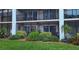 Condo exterior showcasing two screened-in patios with lush landscaping, providing a relaxing outdoor living space at 512 W Venice Ave # 102, Venice, FL 34285