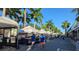 A street scene filled with art vendors and palm trees on a sunny day at 512 W Venice Ave # 102, Venice, FL 34285