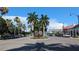 A street view of shops on both sides of a 4-way intersection lined with palm trees at 512 W Venice Ave # 102, Venice, FL 34285