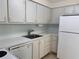 Well-lit kitchen featuring white cabinets, stainless steel sink, and white appliances at 519 Albee Farm Rd # 116, Venice, FL 34285