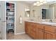 Bathroom with double sinks, granite countertop, and closet with metal shelving for storage at 6037 Shearwater Dr, Englewood, FL 34224