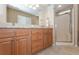 Bathroom featuring double sink vanity with granite countertop and walk-in shower with glass door at 6037 Shearwater Dr, Englewood, FL 34224