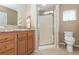 Bathroom featuring single sink vanity with walk-in shower with glass door and toilet at 6037 Shearwater Dr, Englewood, FL 34224
