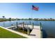 Picture of waterfront home featuring a private dock with bench and American flag at 6037 Shearwater Dr, Englewood, FL 34224