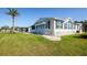 Exterior side view of home showing window awnings, landscaping, and well-maintained lawn at 6037 Shearwater Dr, Englewood, FL 34224