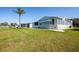Exterior view of home's side with well-kept lawn and mature palm tree at 6037 Shearwater Dr, Englewood, FL 34224