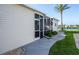 Home's exterior with a screened-in porch, a landscaped yard, and a picturesque view of a lake at 6037 Shearwater Dr, Englewood, FL 34224