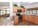 Bright kitchen featuring wooden cabinetry, stainless steel appliances, and granite countertops at 6037 Shearwater Dr, Englewood, FL 34224