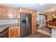 Bright kitchen with stainless steel refrigerator and wood cabinets opens to a dining area at 6037 Shearwater Dr, Englewood, FL 34224