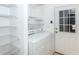 Functional laundry room with washer, dryer, shelving and access door offers convenience and storage at 6037 Shearwater Dr, Englewood, FL 34224