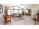 Open living room with vaulted ceiling, large windows, and comfortable seating arrangements at 6037 Shearwater Dr, Englewood, FL 34224