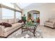 Cozy living room with vaulted ceiling, large windows, comfortable furniture, and decorative floral accents at 6037 Shearwater Dr, Englewood, FL 34224