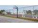 Community tennis and basketball court surrounded by chain link fence at 6037 Shearwater Dr, Englewood, FL 34224