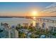 Sweeping aerial view of a waterfront neighborhood with modern architecture, bridge, and a serene ocean sunset backdrop at 614 N Jefferson Ave # 27, Sarasota, FL 34237