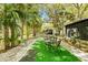 Picturesque backyard featuring an outdoor dining area, screened-in lanai, and verdant tropical surroundings at 614 N Jefferson Ave # 27, Sarasota, FL 34237