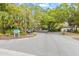 A view of the community road, mature trees, landscaping, and parking at Bermuda Park at 614 N Jefferson Ave # 27, Sarasota, FL 34237