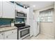 Efficient kitchen design with stainless steel appliances, white cabinets, and bright window at 614 N Jefferson Ave # 27, Sarasota, FL 34237