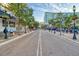 A picturesque street view with brick-paved road, mature trees, outdoor dining, and storefronts in the background at 614 N Jefferson Ave # 27, Sarasota, FL 34237