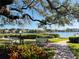 Community picnic area with tables and grill situated near a picturesque waterfront and lush greenery for outdoor enjoyment at 6157 Midnight Pass Rd # D31, Sarasota, FL 34242