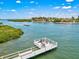 Dock view of a serene waterfront area with a boat gliding by, perfect for relaxing and enjoying the scenic views at 6157 Midnight Pass Rd # D31, Sarasota, FL 34242