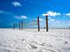 Volleyball nets on a white sand beach, with a clear blue sky background for beach volleyball enthusiasts at 6157 Midnight Pass Rd # D31, Sarasota, FL 34242