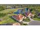 Aerial view of a single-Gathering home with red tile roof overlooking a golf course and lake at 6210 Cormorant Ct, Bradenton, FL 34203