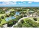 Aerial view of community pool, clubhouse, golf course, tennis courts, and residential homes at 6210 Cormorant Ct, Bradenton, FL 34203