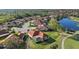 Aerial view of a residential neighborhood with red tile roofs surrounding a golf course and lake at 6210 Cormorant Ct, Bradenton, FL 34203
