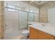 Well-lit bathroom with a large mirror, vanity, and a shower-tub combination with sliding glass doors at 6210 Cormorant Ct, Bradenton, FL 34203