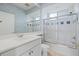 Bright bathroom featuring patterned blue wallpaper, a large mirror, and a shower with glass sliding doors at 6210 Cormorant Ct, Bradenton, FL 34203
