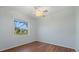 Bright bedroom with hardwood floors, a ceiling fan, and a large window overlooking the landscape at 6210 Cormorant Ct, Bradenton, FL 34203