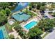 Aerial view of community clubhouse, pool, and tennis courts surrounded by mature trees and landscaping at 6210 Cormorant Ct, Bradenton, FL 34203