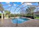 Enclosed pool and spa area with brick decking, surrounded by lush landscaping at 6210 Cormorant Ct, Bradenton, FL 34203