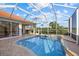 Screened-in pool with brick trim and clear blue water overlooks the green golf course in the distance at 6210 Cormorant Ct, Bradenton, FL 34203