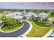 Aerial view of community center featuring manicured landscaping and circular driveway at 651 Back Nine Dr, Venice, FL 34285