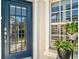 Inviting front entrance with a glass-paneled door, sidelight windows, and a potted plant at 651 Back Nine Dr, Venice, FL 34285