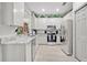 Modern white kitchen featuring stainless steel appliances, light countertops, and sleek cabinetry at 651 Back Nine Dr, Venice, FL 34285