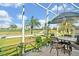 View of golf course from covered lanai, complete with patio table and chairs at 651 Back Nine Dr, Venice, FL 34285