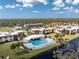 Aerial view of a community featuring a large pool, well-manicured lawns, and charming residential buildings at 66 Boundary Blvd # 275, Rotonda West, FL 33947