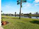 A lush green backyard with a scenic view of the canal and neighborhood homes at 66 Boundary Blvd # 275, Rotonda West, FL 33947