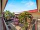 View of courtyard area with picnic tables, umbrellas, greenery, and building in the background at 66 Boundary Blvd # 275, Rotonda West, FL 33947