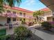 Courtyard featuring picnic tables, umbrellas, and building with red roofing in the background at 66 Boundary Blvd # 275, Rotonda West, FL 33947