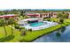 Aerial view of a community pool with ample seating, lush landscaping, and nearby residential buildings at 66 Boundary Blvd # 275, Rotonda West, FL 33947