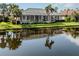 Screened-in lanai overlooking a tranquil pond, surrounded by lush greenery and landscaping at 692 Egret Walk Ln, Venice, FL 34292