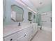Bathroom with double sinks, framed mirrors, vanity, and a shower/tub combo at 692 Egret Walk Ln, Venice, FL 34292
