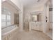 Bright bathroom features a soaking tub, walk-in shower, and vanity with ample counter space at 692 Egret Walk Ln, Venice, FL 34292