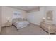 Bright bedroom features a wicker dresser, a bed with pillows, and a closet at 692 Egret Walk Ln, Venice, FL 34292