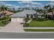 Charming single-Gathering home with a well-manicured lawn, mature palm trees, and a brick driveway at 692 Egret Walk Ln, Venice, FL 34292