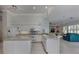Open kitchen featuring an island, white appliances and a view of the adjacent living area at 692 Egret Walk Ln, Venice, FL 34292